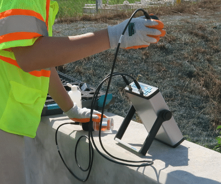 A technician performing compressive strength tests on construction materials