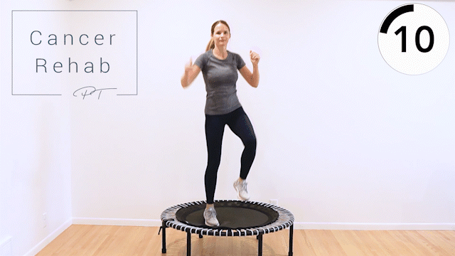 A woman doing side crunches on a mini trampoline as she bounces and alternates sides.