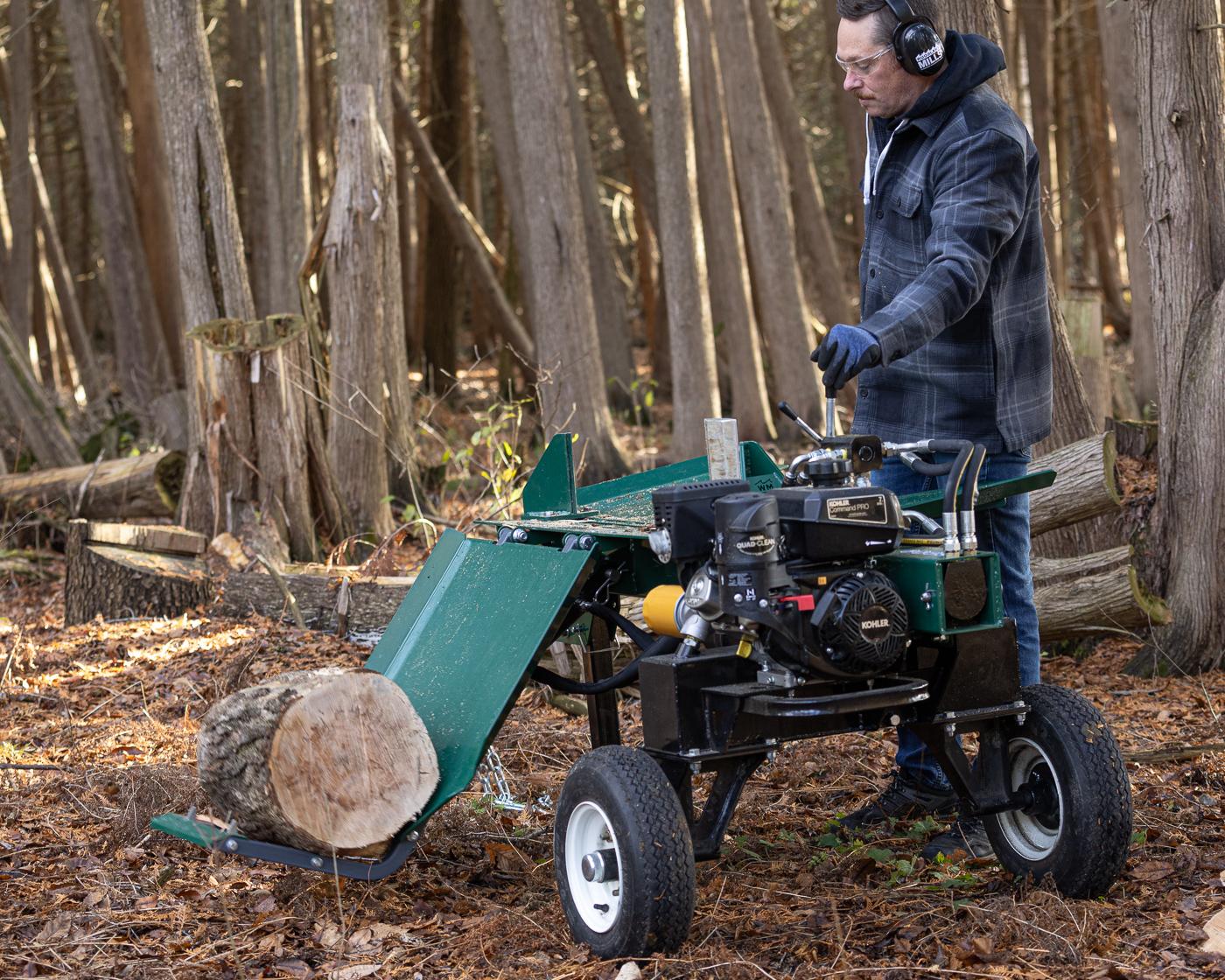 A hydraulic lifting table lifting a large log onto the table of a Woodland Mills LS218 Log Splitter.