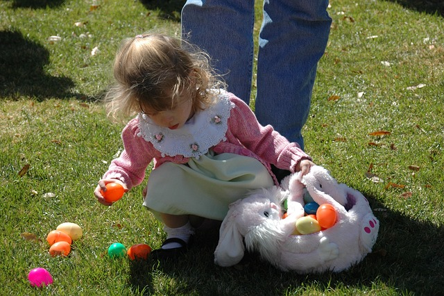 dziewczynka na Wielkanoc szuka jajek w ogrodzie