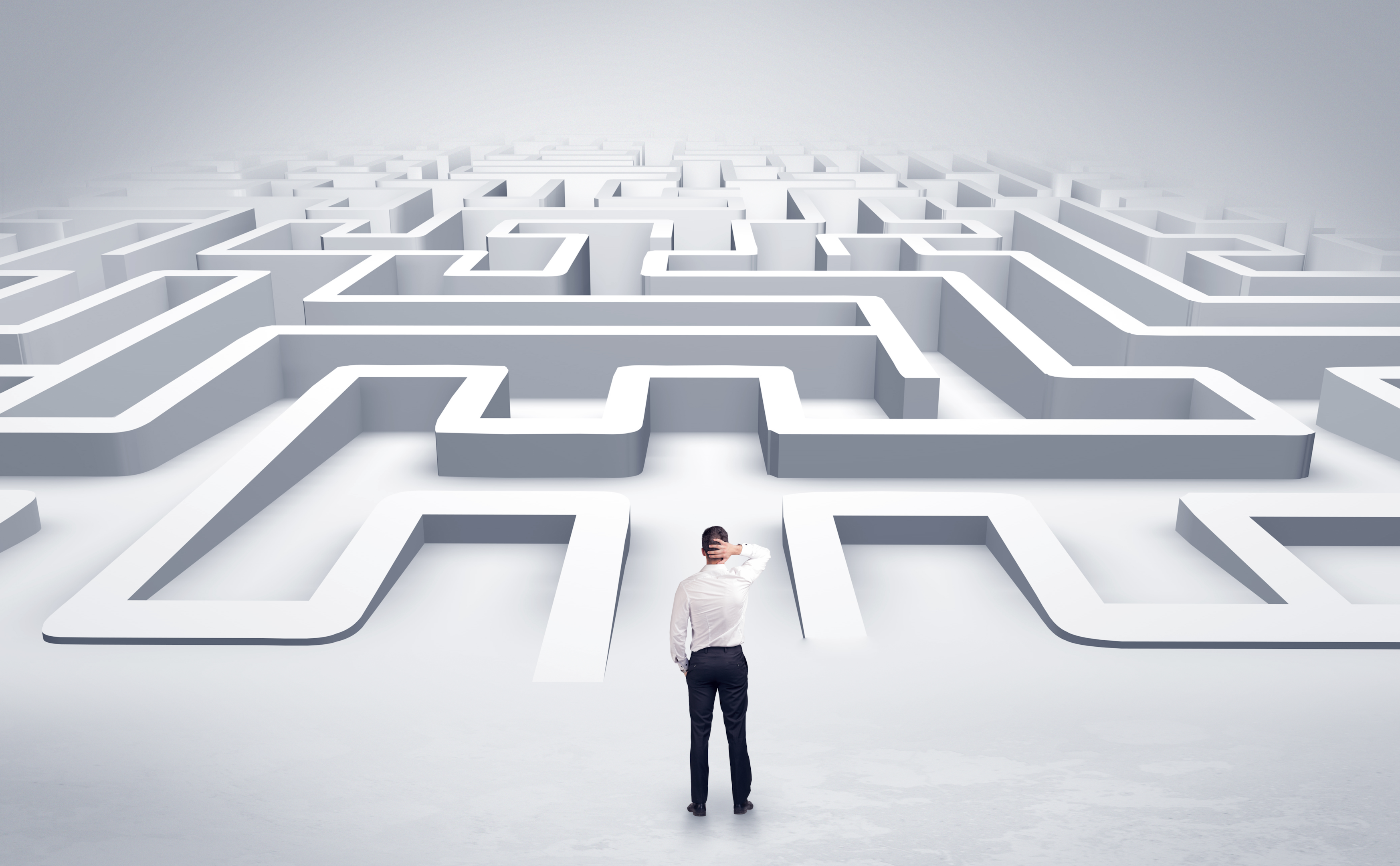 A corporate man in front of a maze.