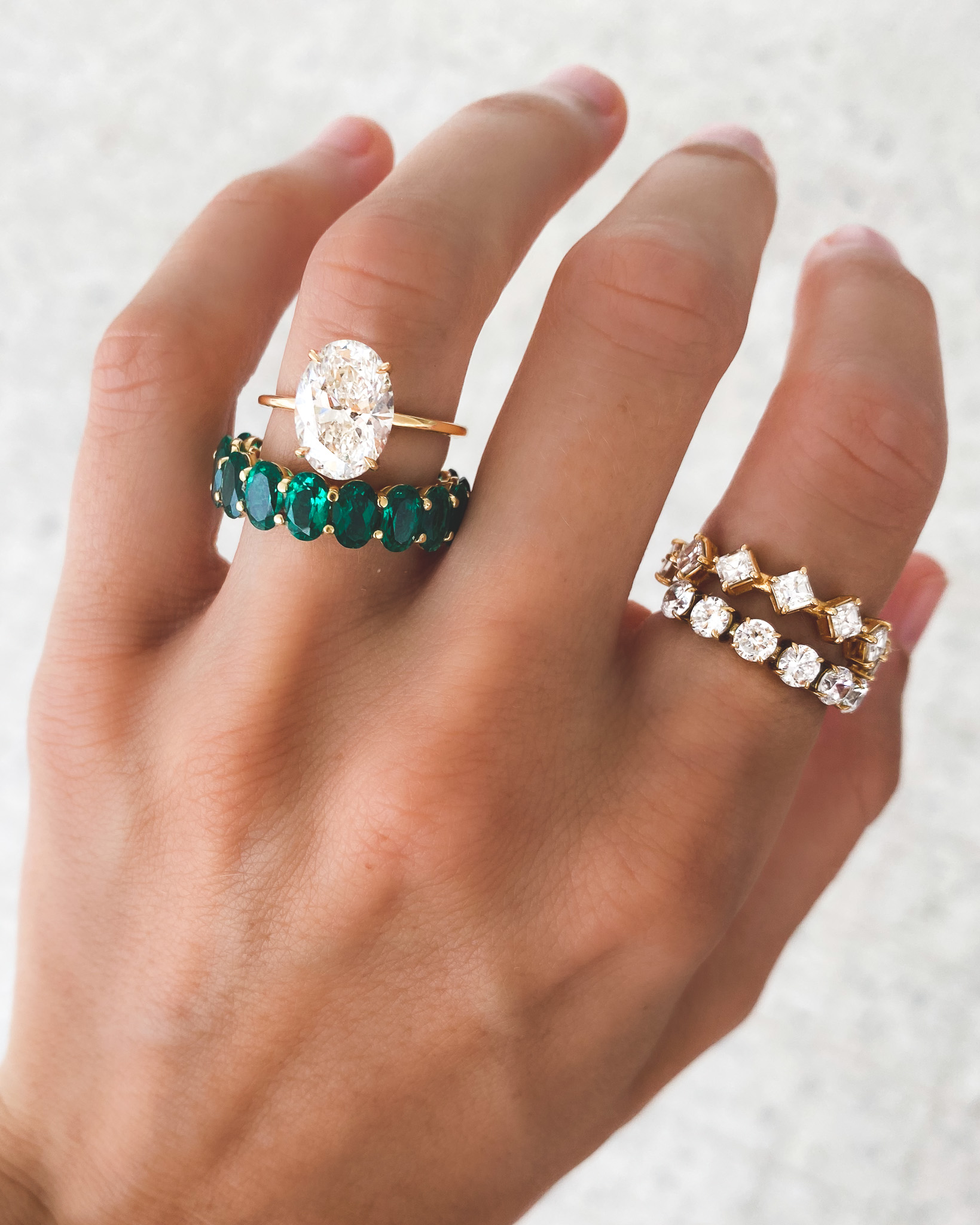 Un hermoso anillo de compromiso ovalado con un diamante en el centro y una pequeña alianza de eternidad.