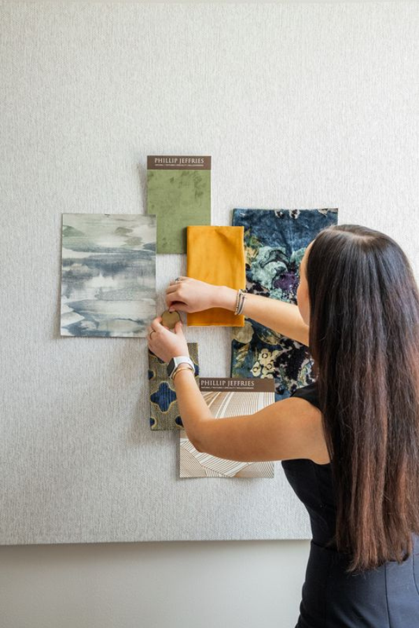 a designer pins fabric samples to a mood board