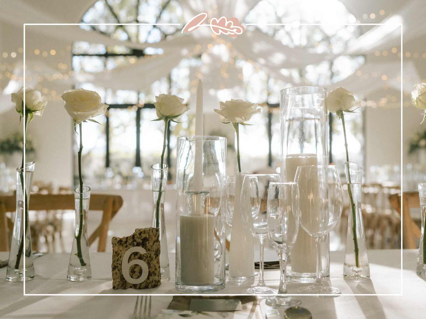Wedding table styling with single white roses in clear glass bud vases and pillar candles at Tess and Greg's Nantes Estate reception