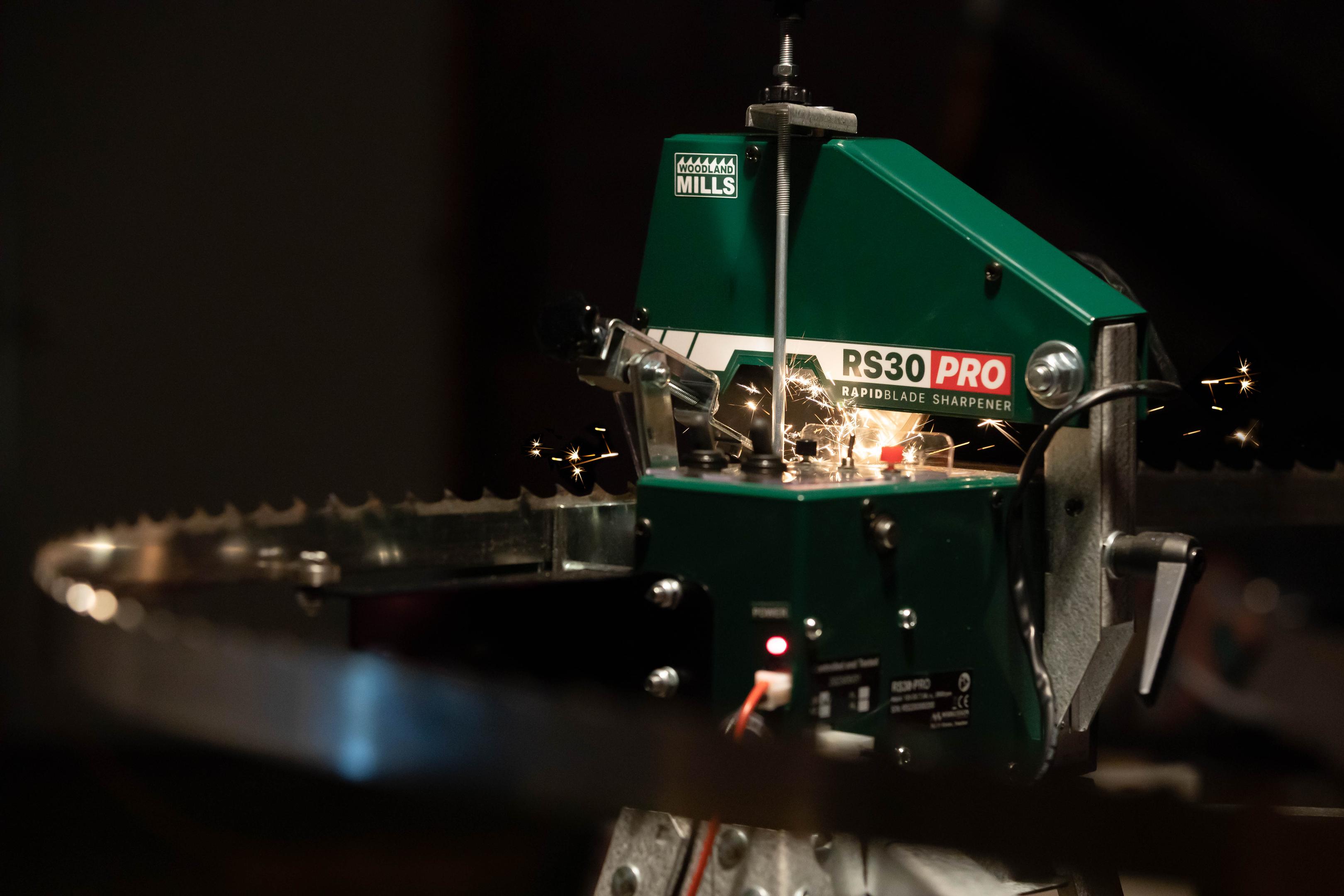 A Woodland Mills RS30 PRO Bandsaw Blade Sharpener grinding the tip of a bandsaw blade tooth.