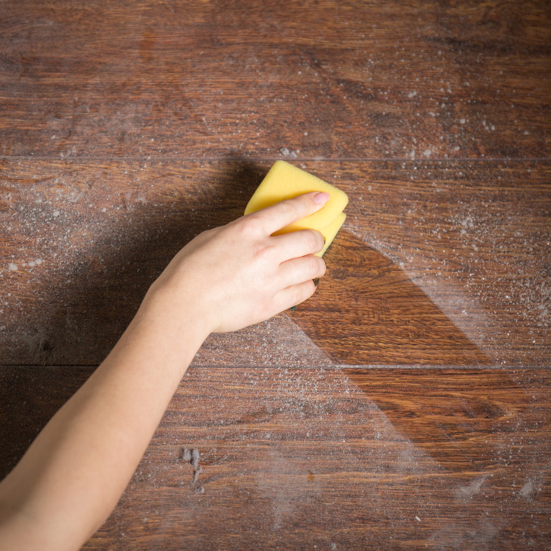 person wiping dust with a sponge