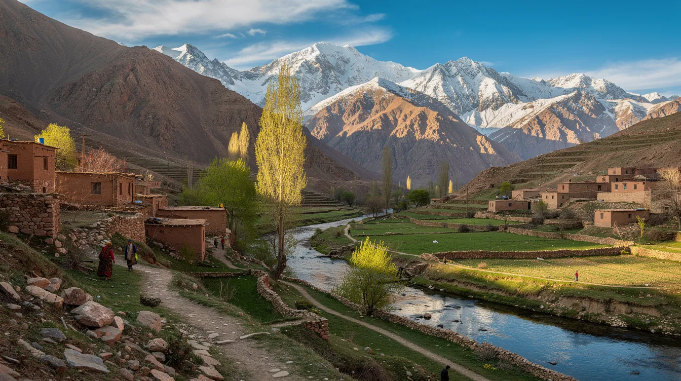 A imagem mostra o Vale de Imlil, em Marrocos, cercado por montanhas majestosas e vegetação exuberante. Este destino de turismo atrai visitantes em busca de experiências autênticas na cultura marroquina e na arquitetura tradicional das aldeias.