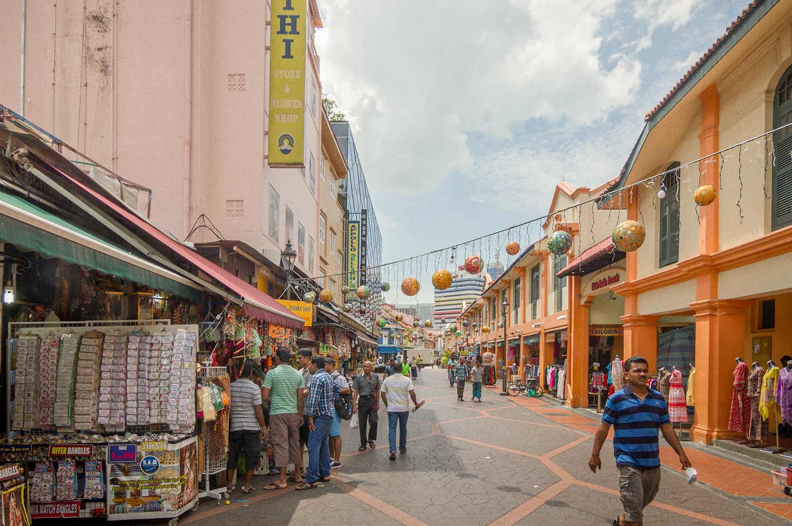 A lively Campbell Lane lined with shops and market stalls, with people walking along the street under hanging decorative lanterns.