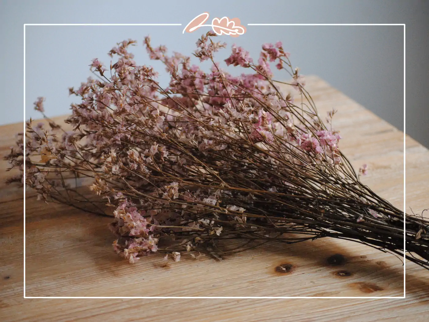 A simple bouquet of dried pink flowers, neatly arranged on a wooden surface. Fabulous Flowers and Gifts.