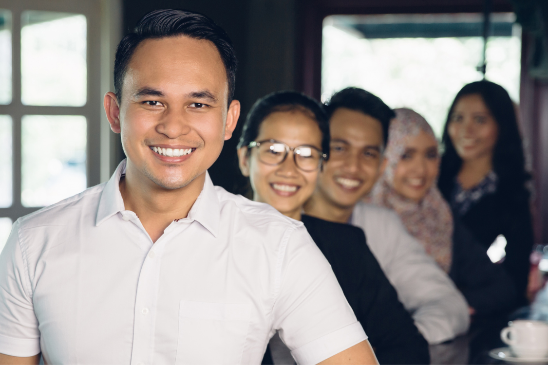 Smiling Filipino professionals standing in a row, showing strong team morale and job satisfaction