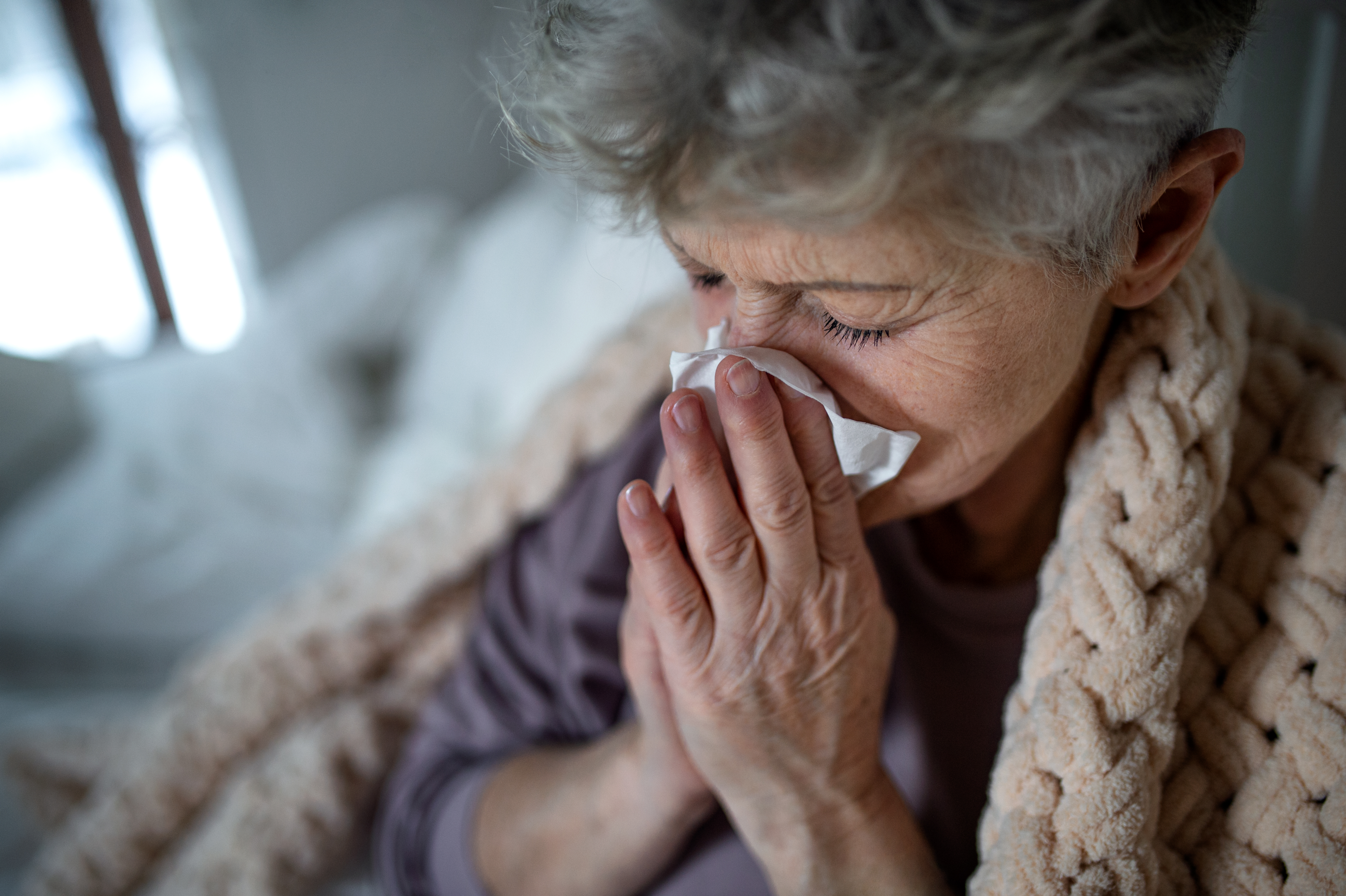 An image showing a senior woman performing throat cleaning, a common practice while taking blood pressure medications.