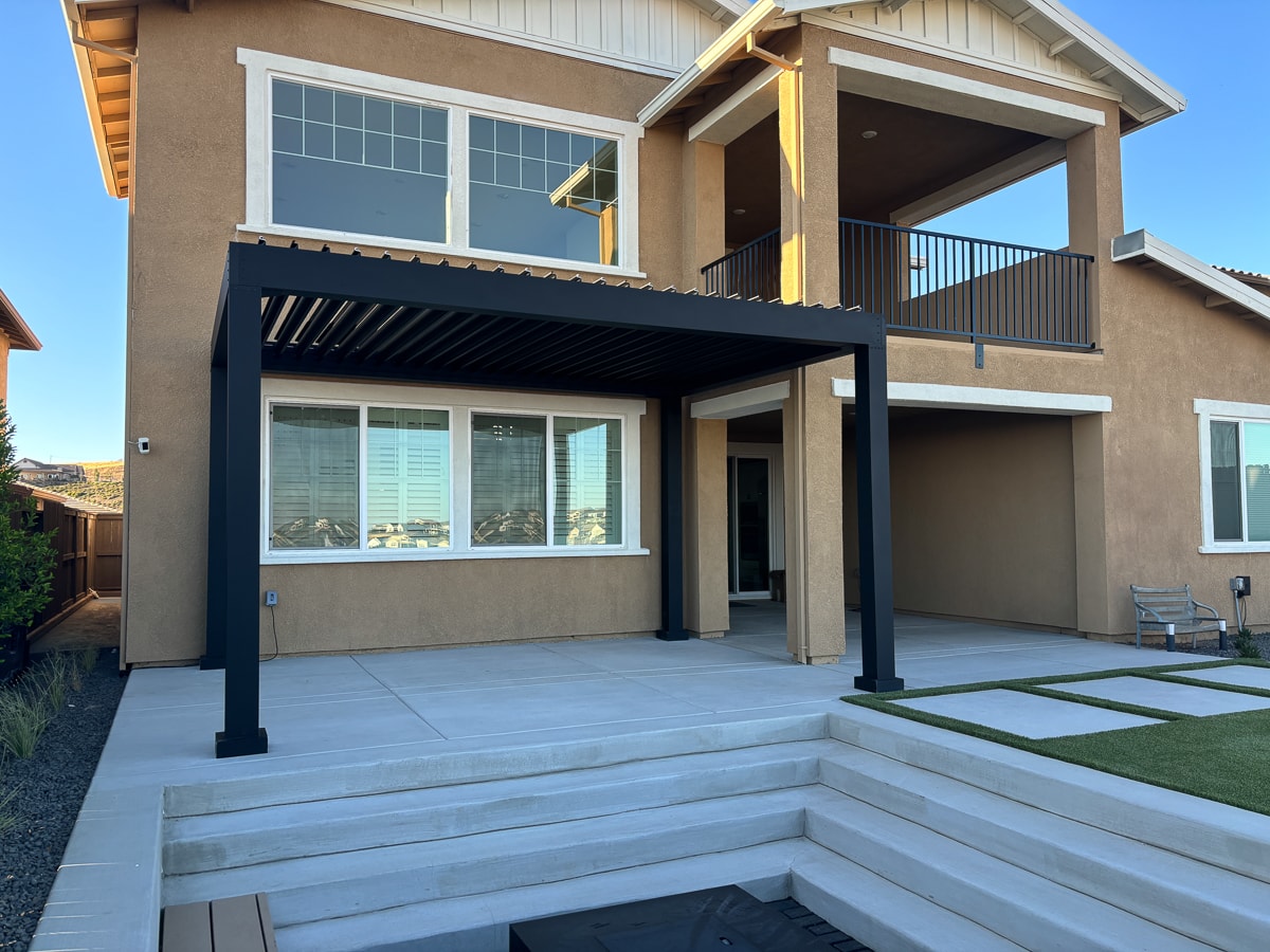 Aluminum pergola on patio in black with black louvers.