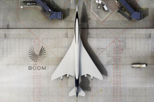 Boom supersonic airplane Overture stationed at an airport gate.