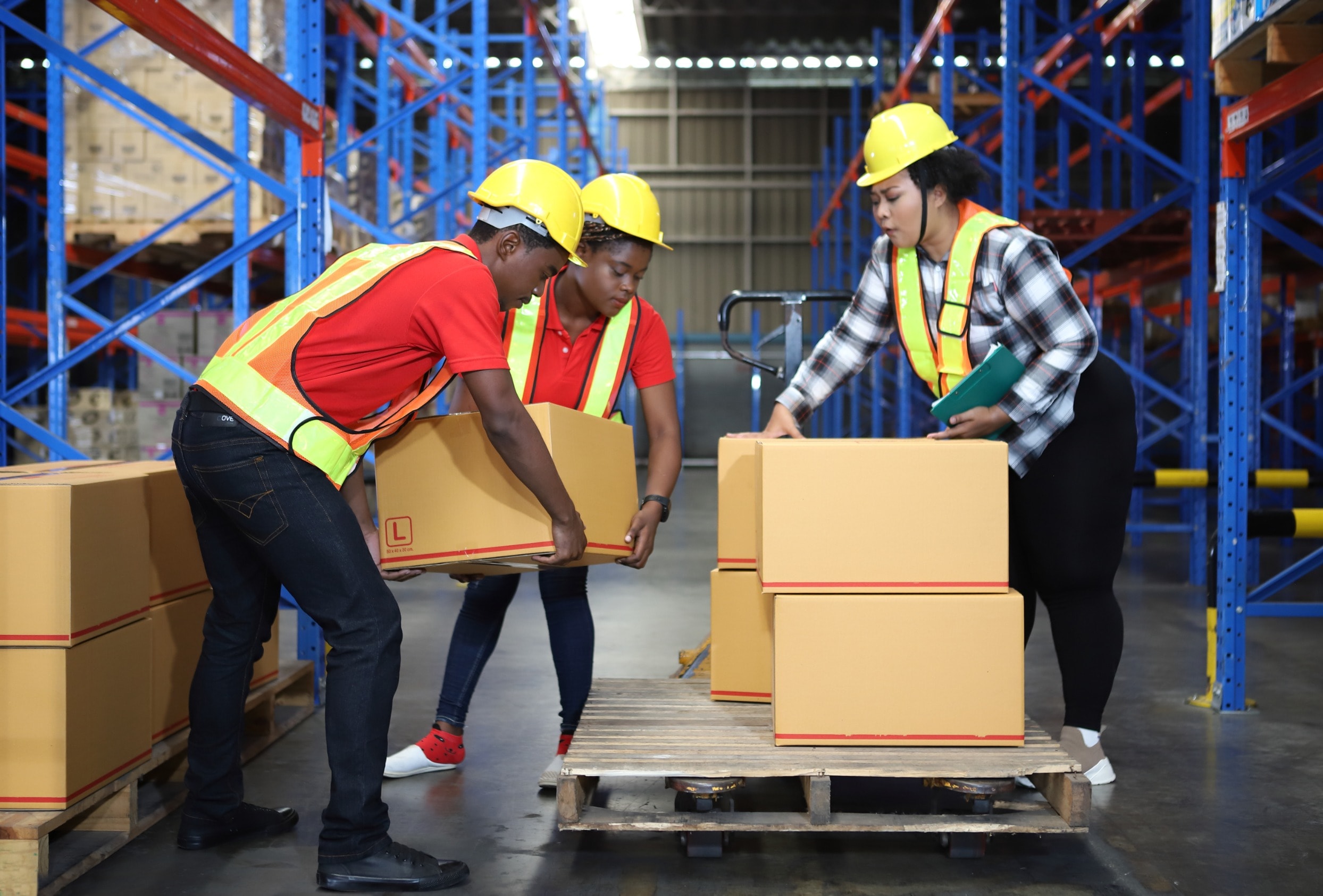 A team of workers follow workplace  health and safety procedures to lift a box together