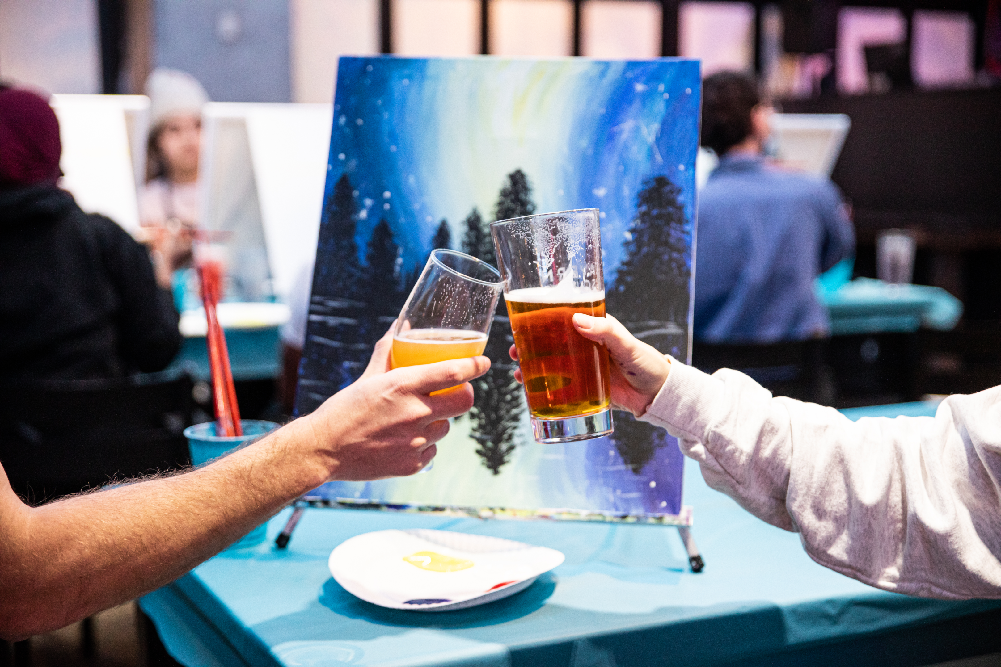 two people cheersing at a Paint Nite fundraising event 