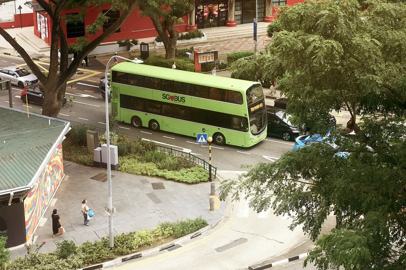 Green SBS double-decker bus on residential street.