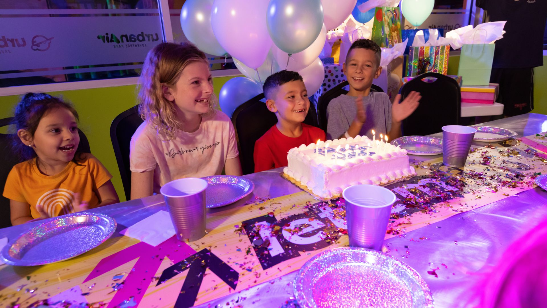 A 6-year-old boy gets ready to blowout the candles surrounded by friends at his Urban Air Birthday Party