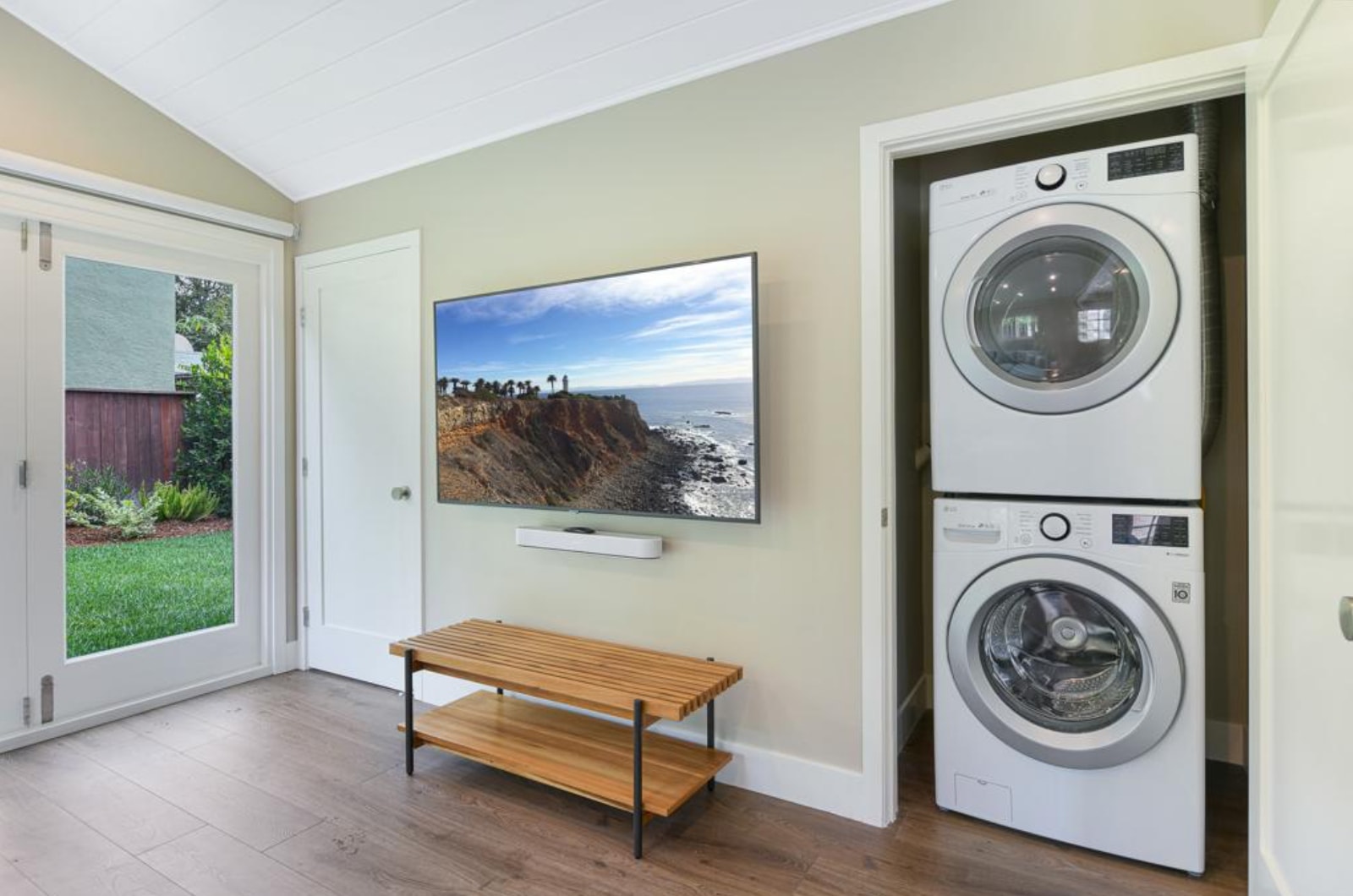 Room with washer, dryer, coffee table, and television