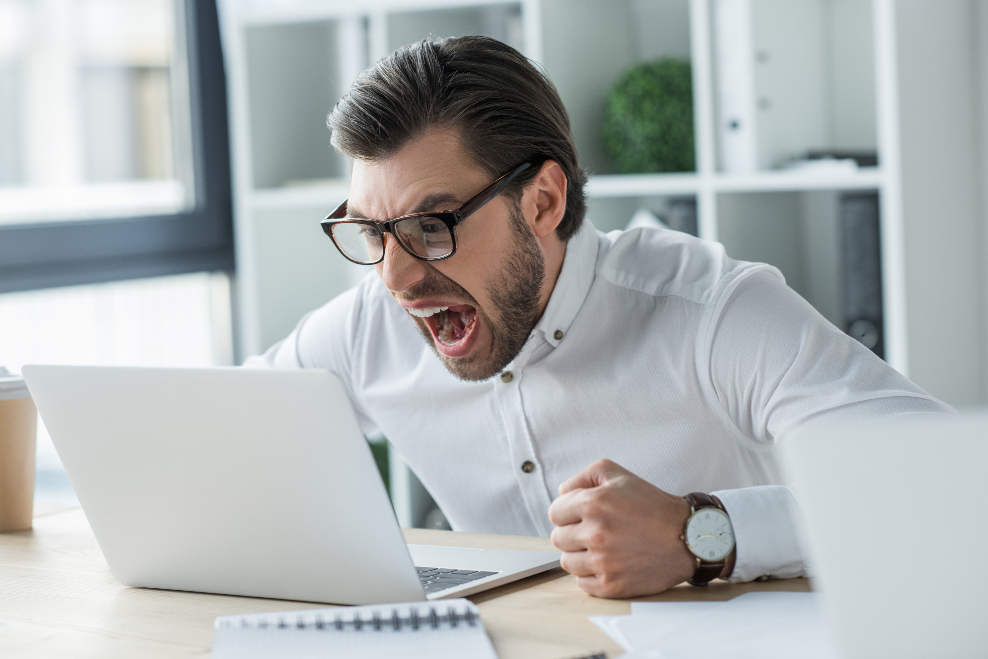 man shouting in the fron of his laptop