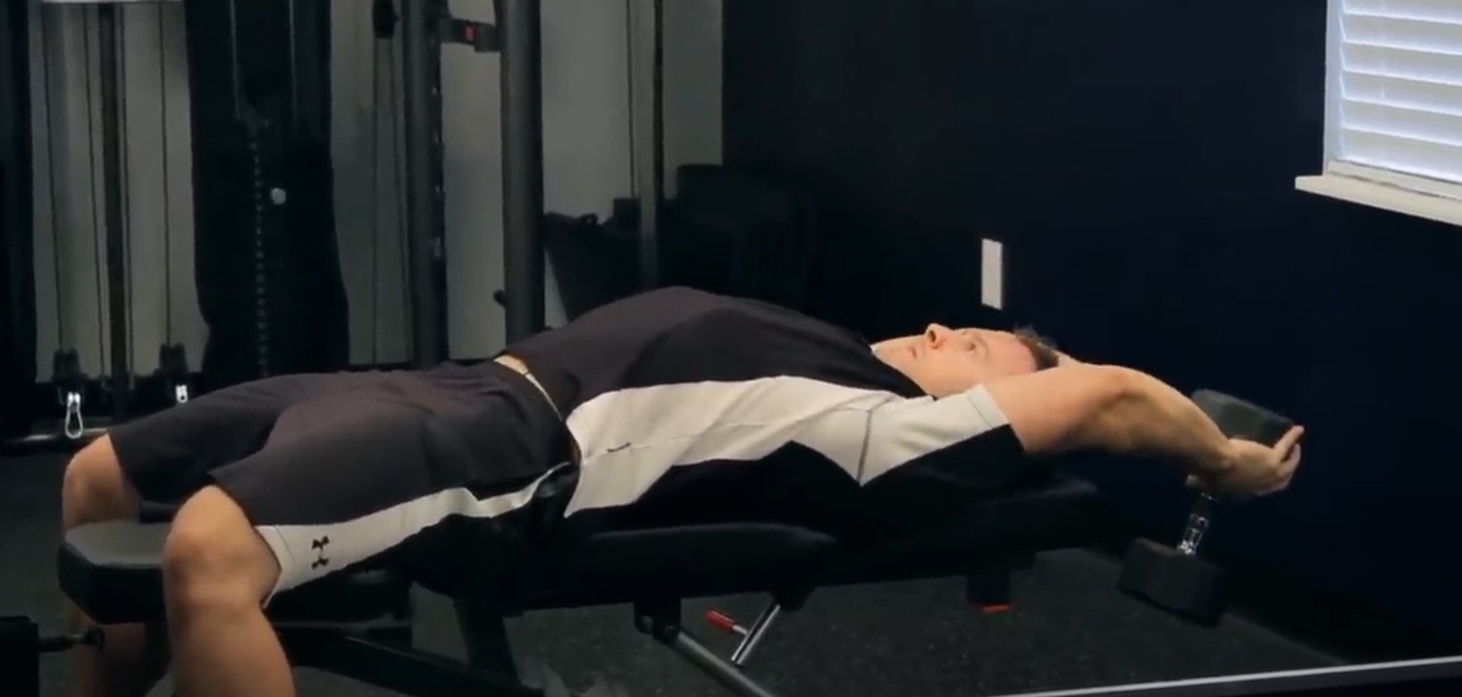 Man performing dumbbell pullover on a weight bench