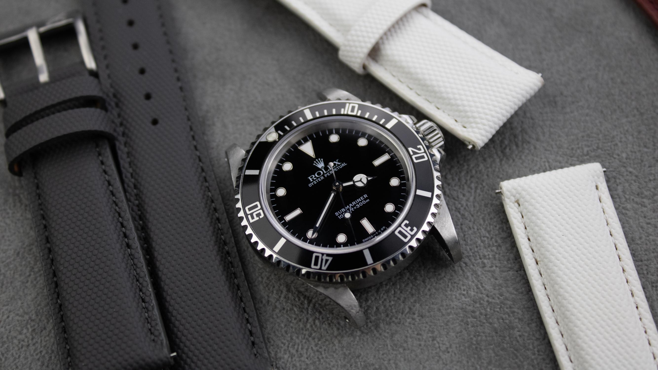 A variety of grey sailcloth watch straps styled with different watches.