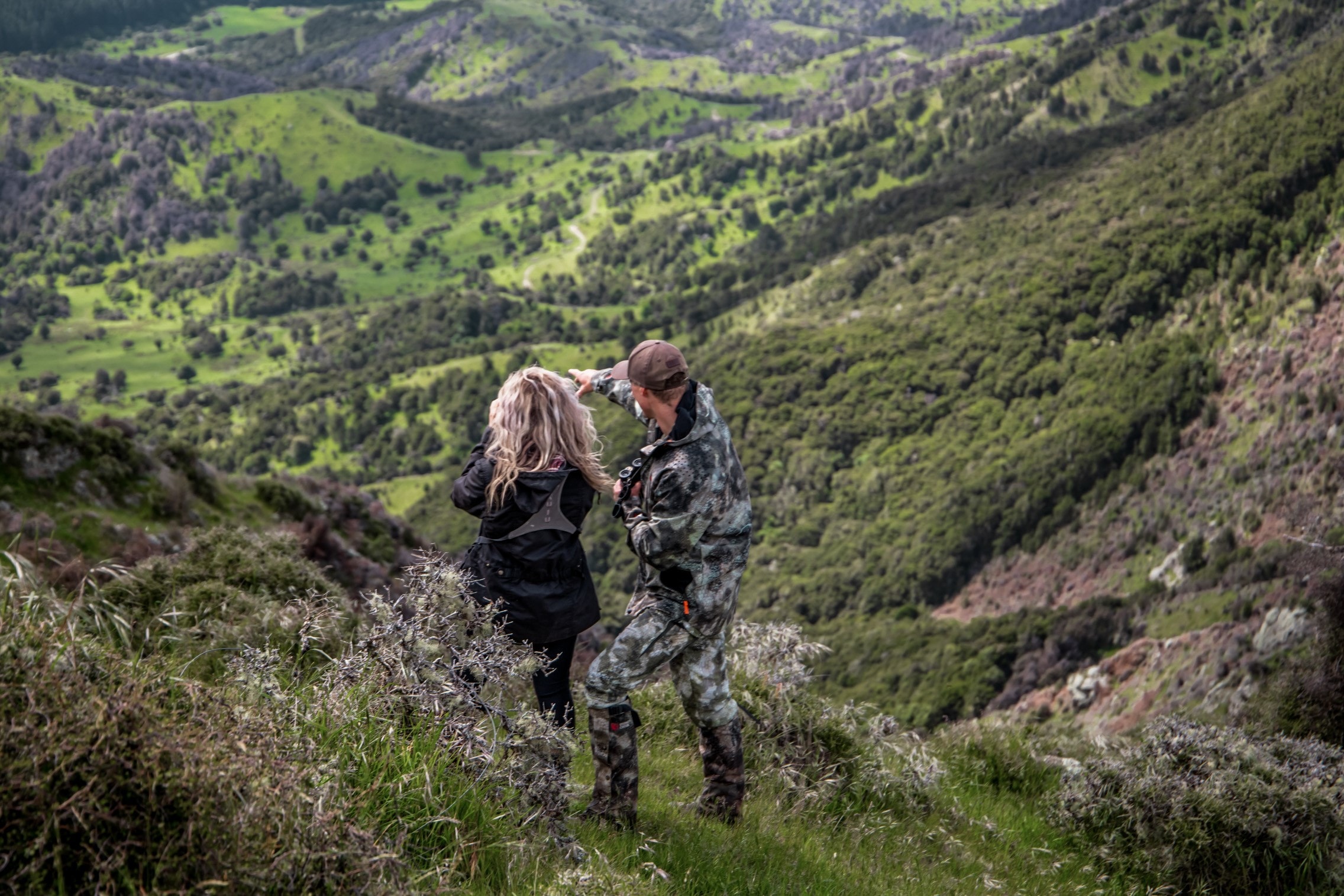 A guide takes their hunter glassing for red stag on a mountain side. 
