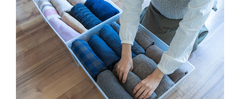 Folding your clothes into plastic bins is one way to store your clothes and save space.