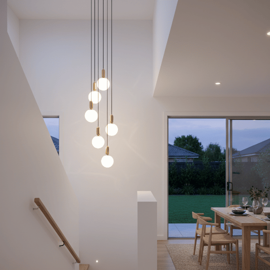 Cluster of globe pendant lights hanging at varying heights in a stairwell.
