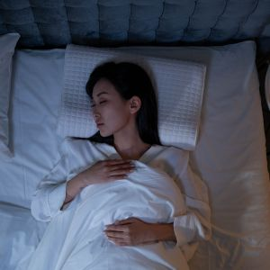 A woman sleeping so she can fully rest and feel happier