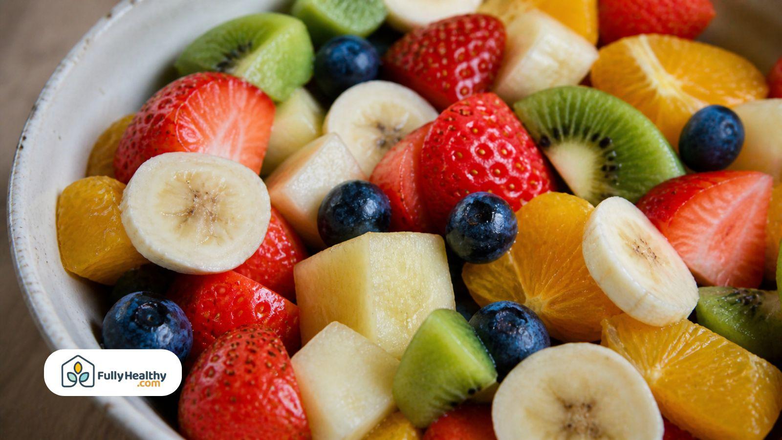 Fresh fruit salad with strawberries, bananas, blueberries, kiwi, and orange slices in a bowl.