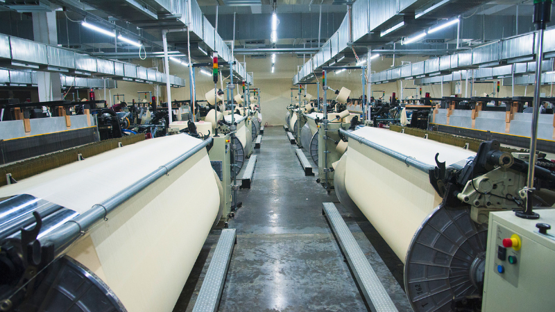 A factory with many machines that are used to make fabric
