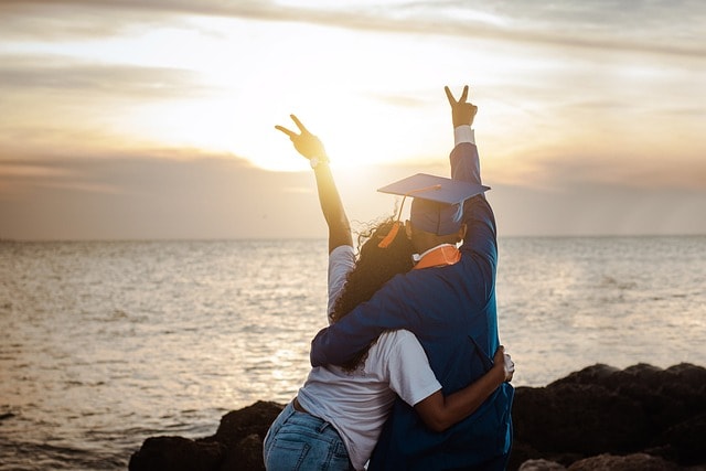 A young graduate celebrates achievement, but a pile of student loan bills shows the financial burden ahead.