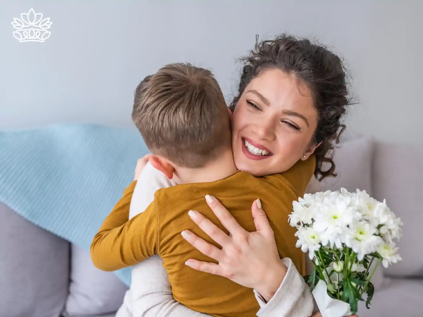 A mother embracing her child who is holding a bouquet of white daisies. Fabulous Flowers and Gifts. Flower Delivery to Cape Town Collection.