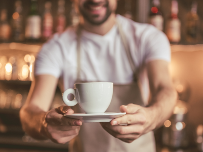 Barista segura xícara de café. Foto: GeorgeRudy de Getty Images - Canva