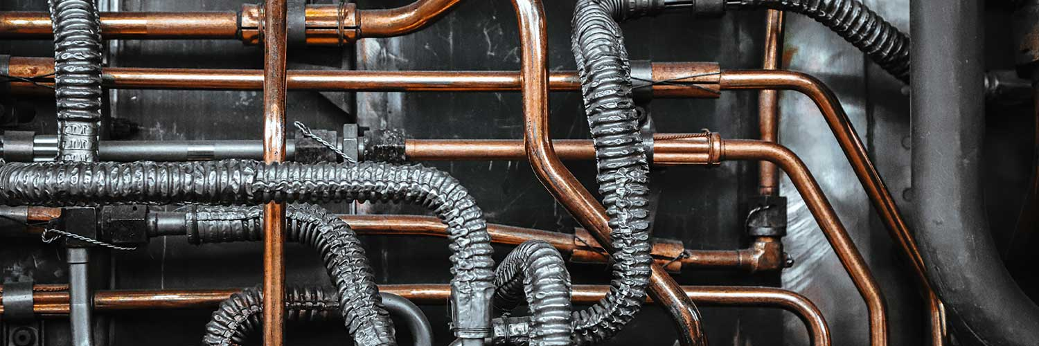 A plumber running water supply lines during the rough-in plumbing process