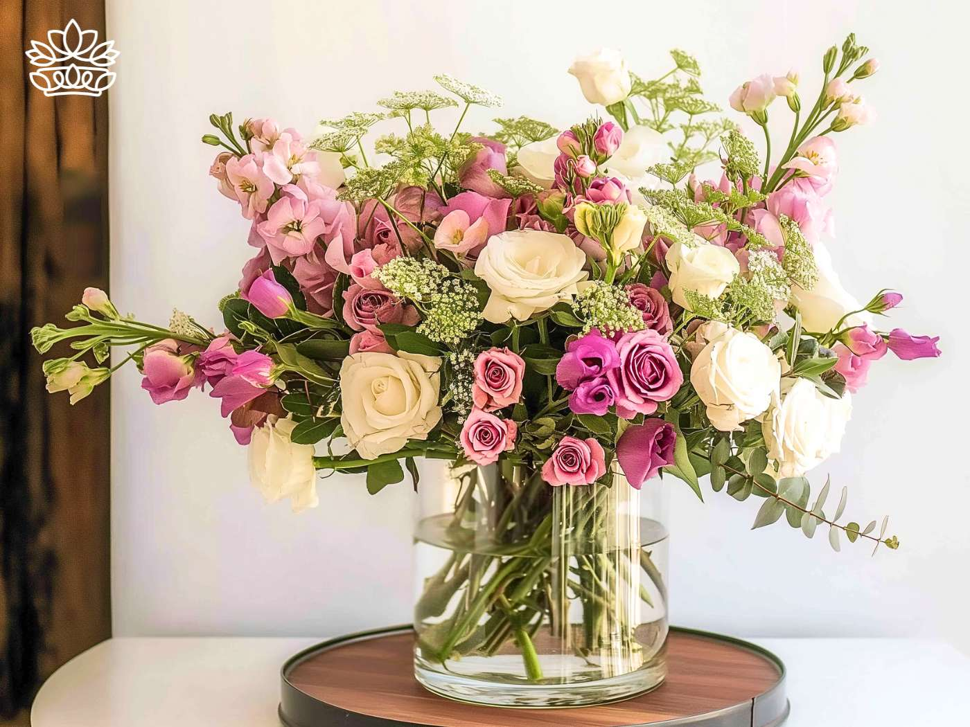 Elegant flower arrangement featuring a blend of pink snapdragons, creamy roses, and deep purple blooms in a clear glass vase, from Fabulous Flowers and Gifts.