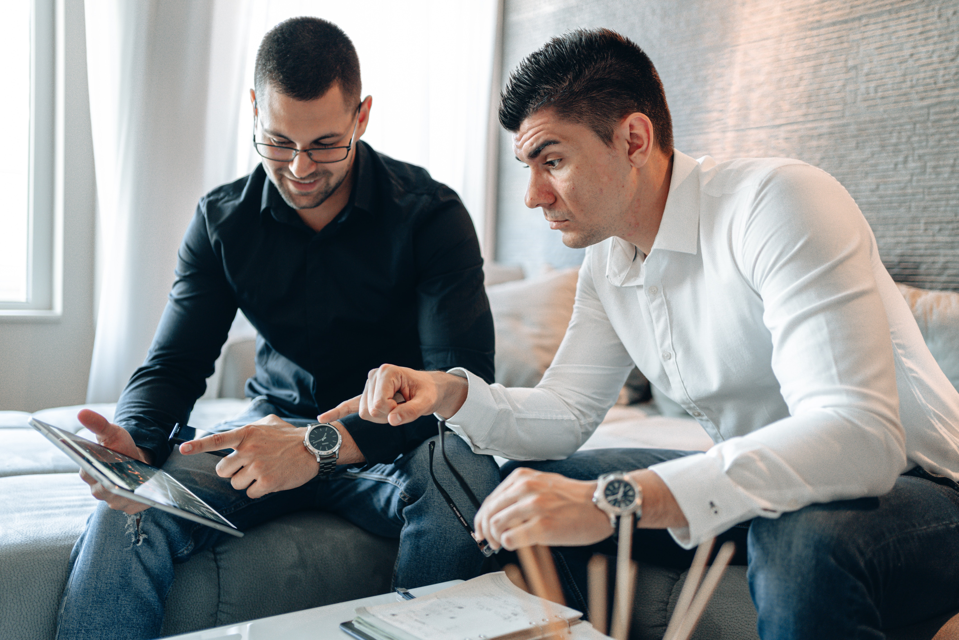 Two potential tenants reviewing month to month rentals on a tablet