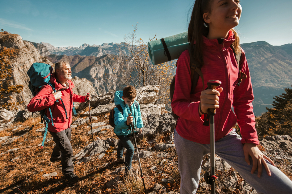 family on trekking poles with backpacks 