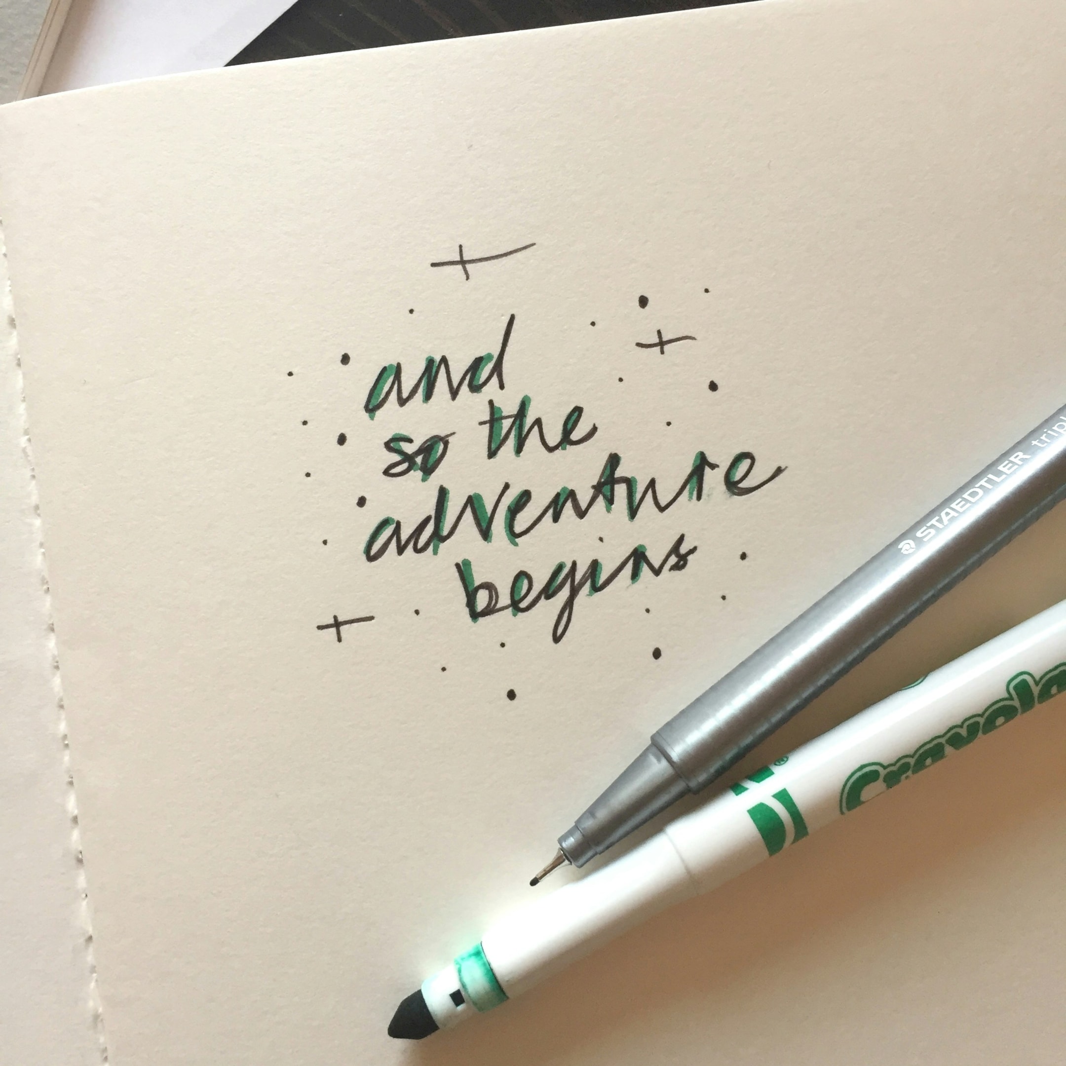 A notebook with the phrase 'and so the adventure begins'.