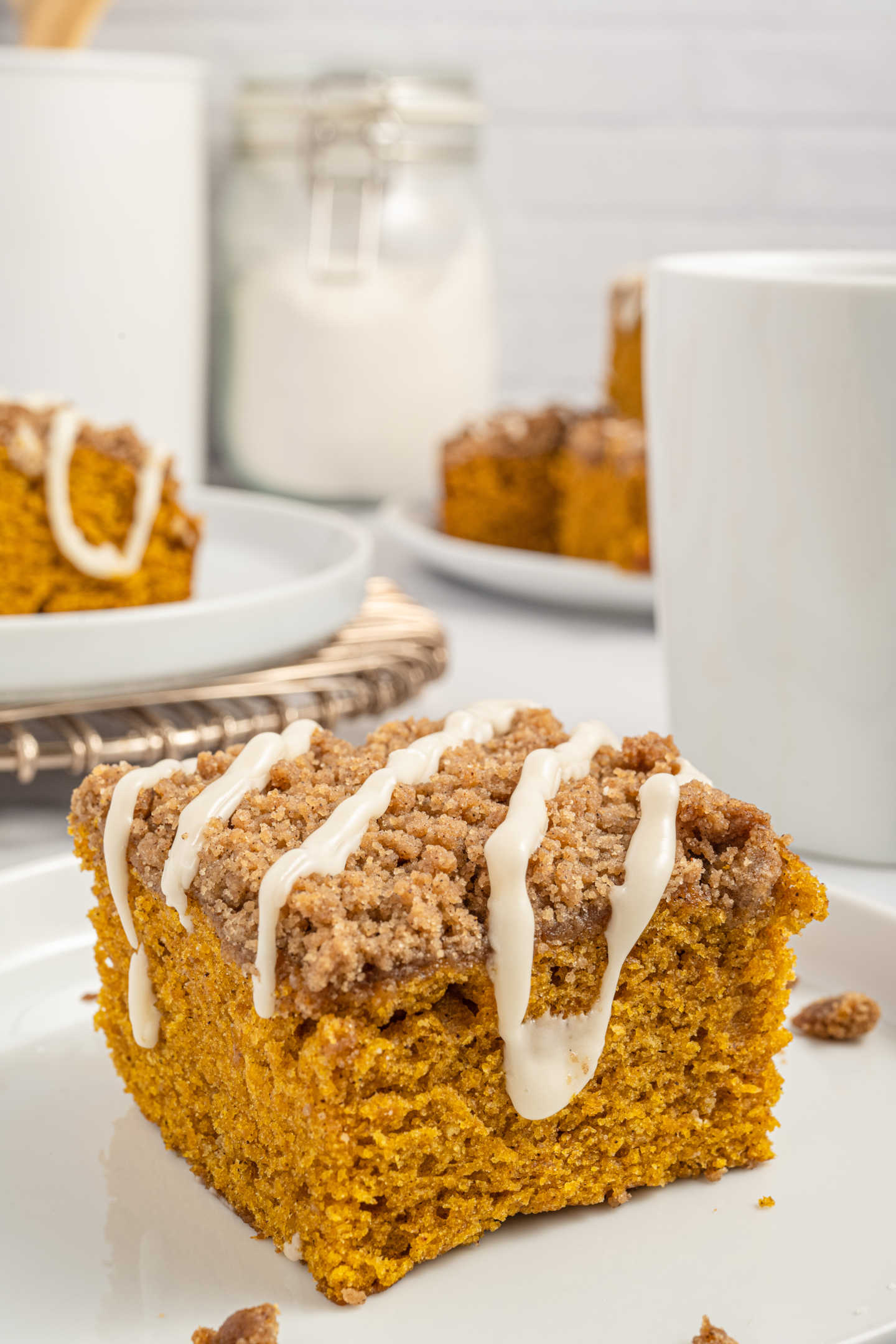 slice of pumpkin coffee cake on a plate drizzled in icing