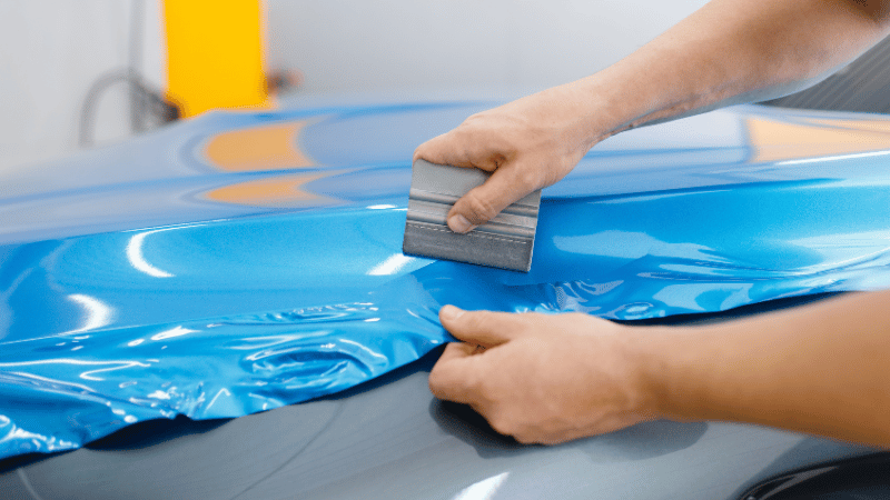 A man is applying the cast vinyl film.