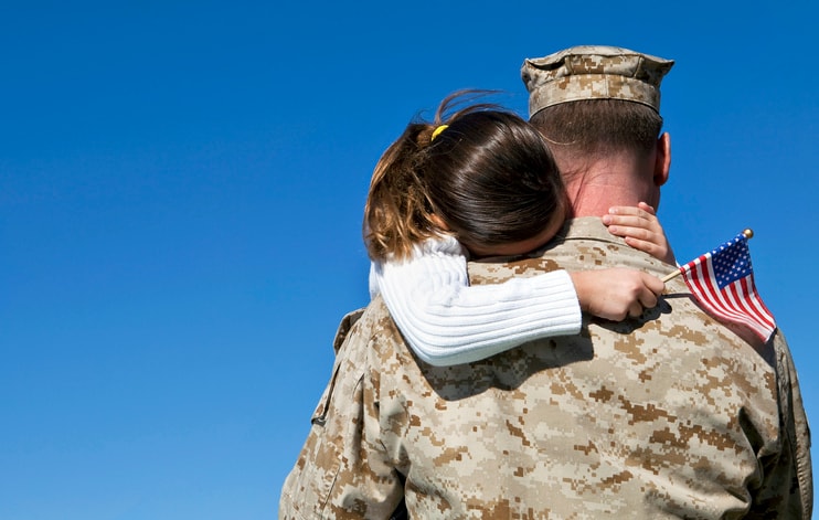 Serviceman holding his young daughter.