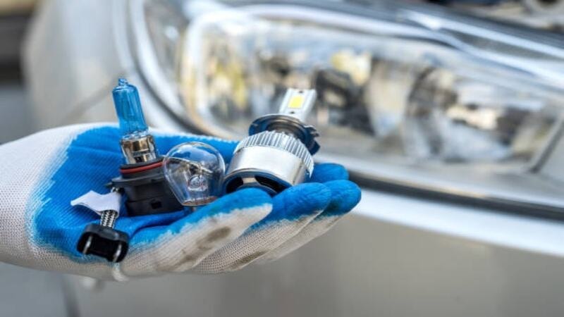 A professional gathering different components for fixing a car headlight.