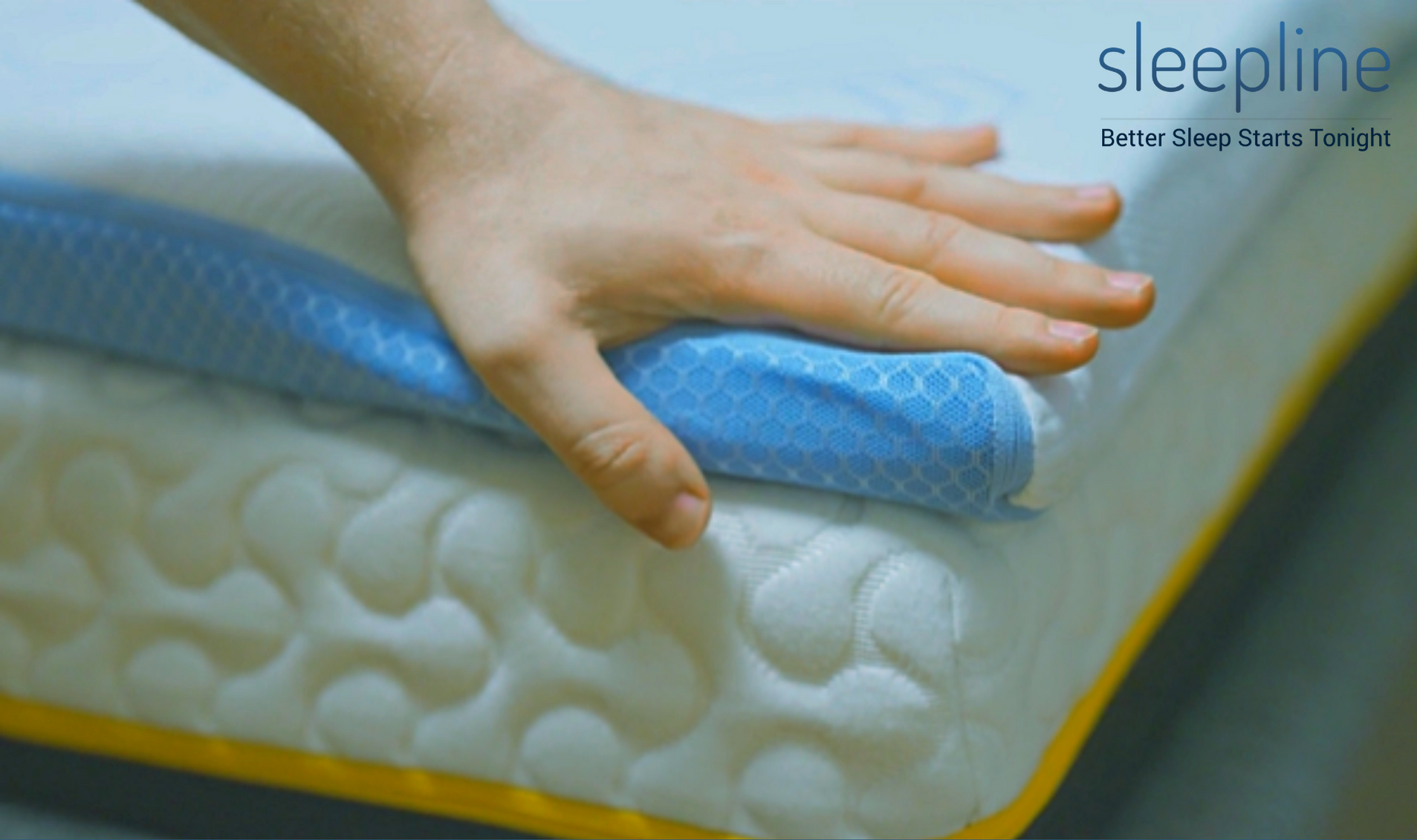 A person's hand on a mattress topper