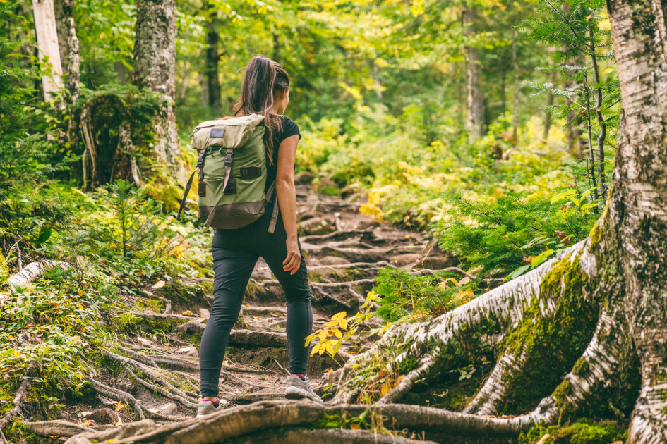 Female hiker in form-fitting leggings trekking through a lush forest, emphasizing the lightweight and comfortable design.