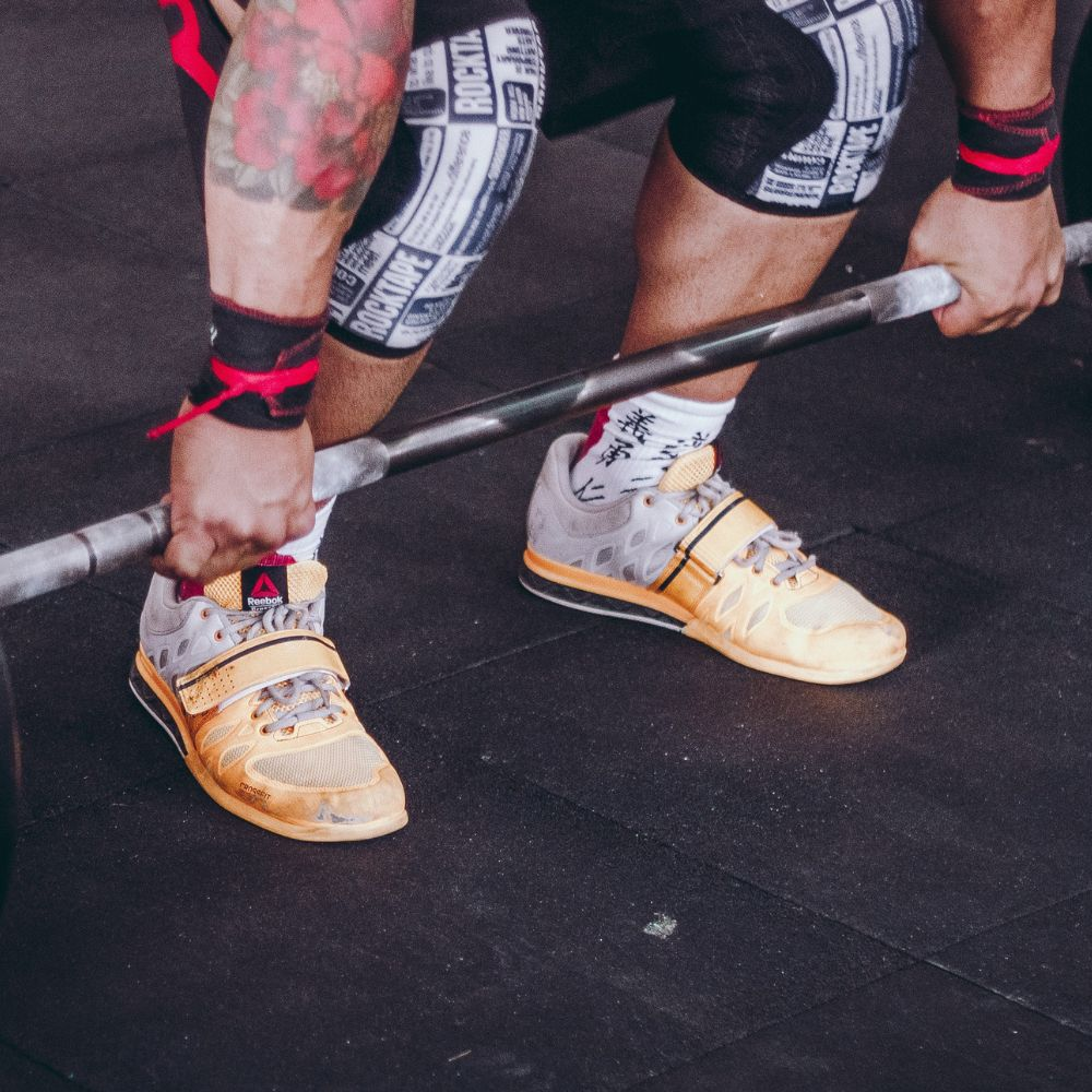 A person using chalk to improve their grip strength while lifting heavy weights