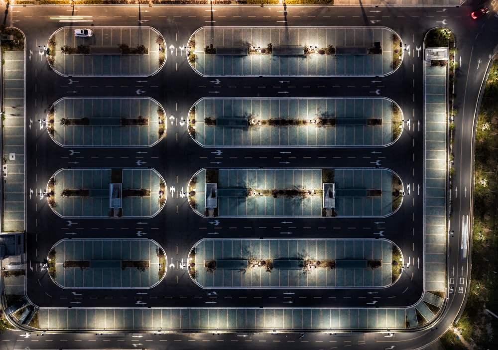 A late night aerial shot of a parking lot with any vehicle plate numbers automatically captured.