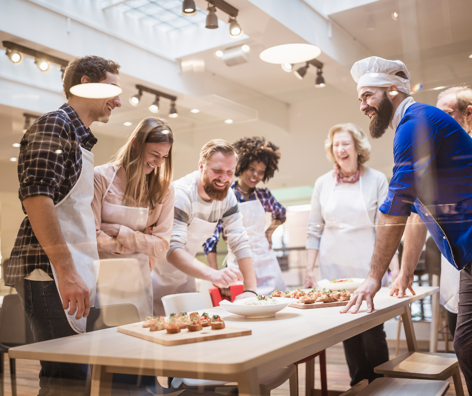 An image of a group of people enjoying a cooking class together, one of the social activities that don't involve drinking in our culinary adventures experience.