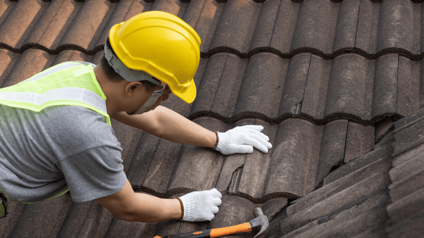 Roofers repairing the old roof of a rental property in Toledo, Ohio as part of a renovation project.