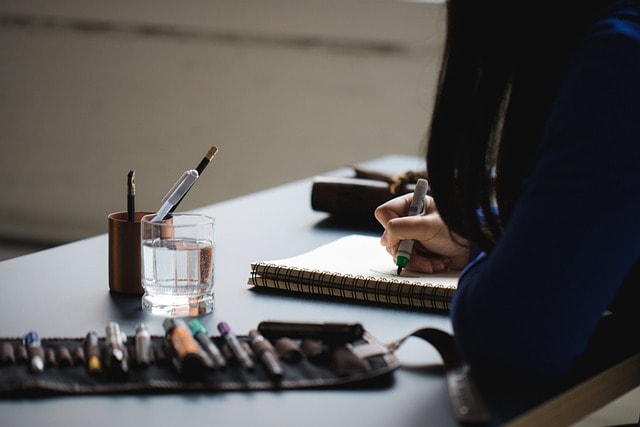 Calligraphy starter kit featuring pens, writing materials, and a woman practicing